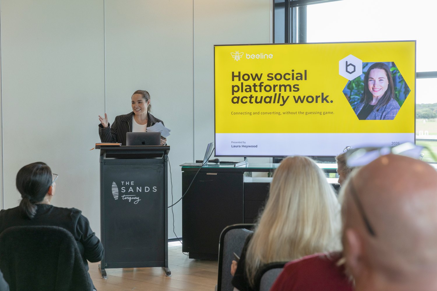 Laura presenting to a local business group, with the Beeline brand on screen